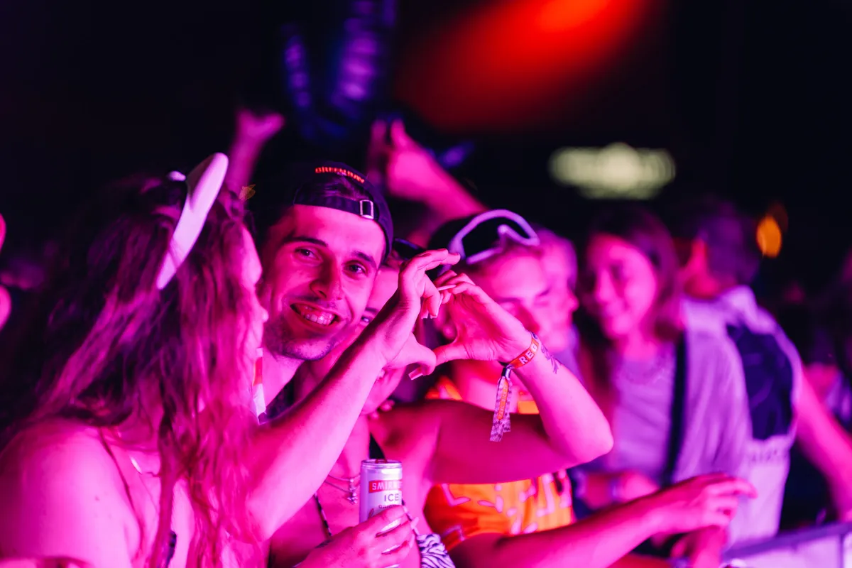 Deejay Plus beim Festival mit Publikum und DJs im Hintergrund.
